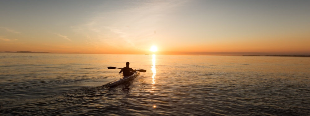 Boot fährt in den Sonnenaufgang